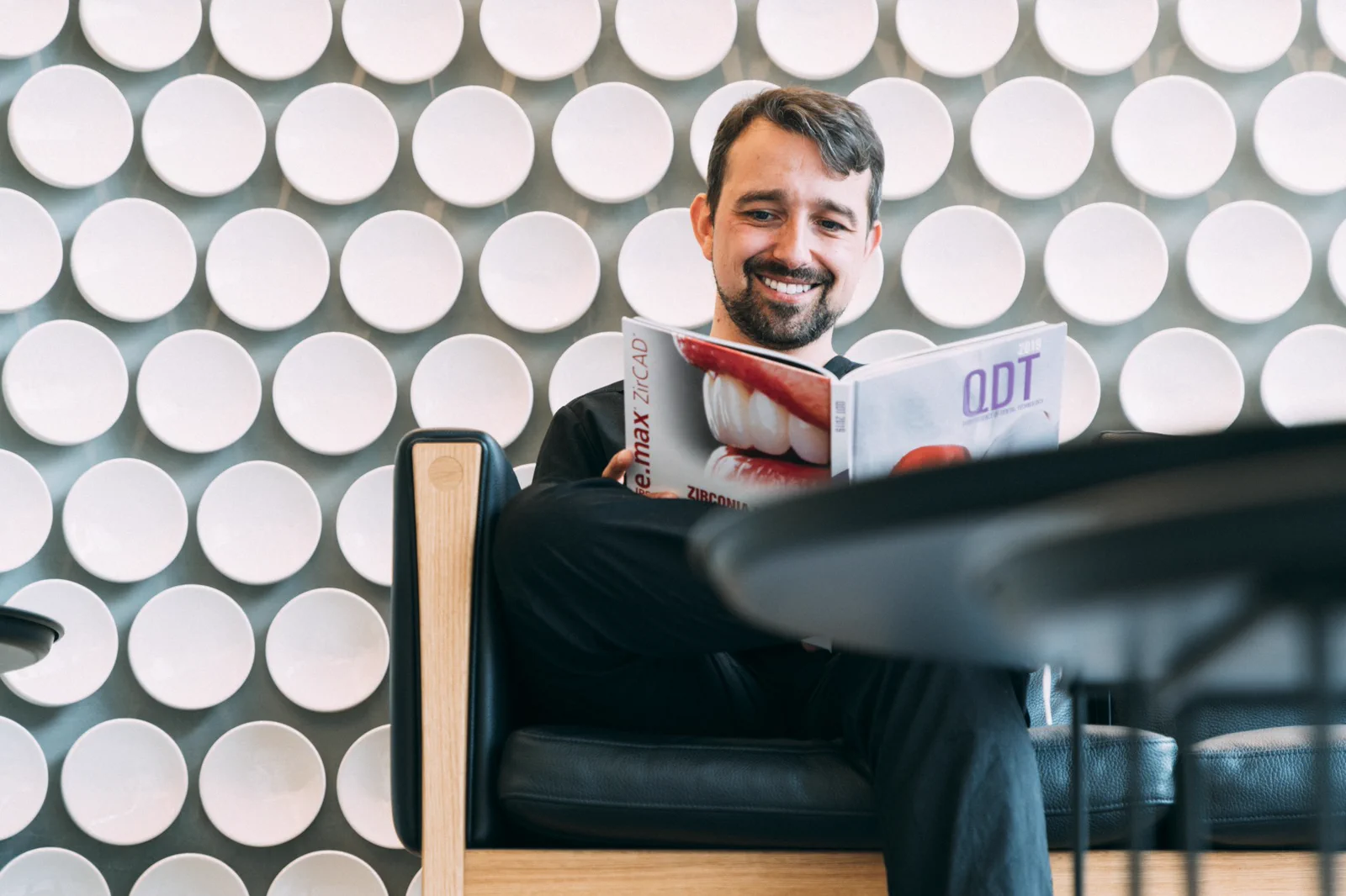 Dr Pedro Gutierres reviews professional dental material in the clinic lounge.